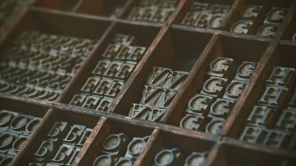 Image showing stamps of various letters, separated into wooden boxes.