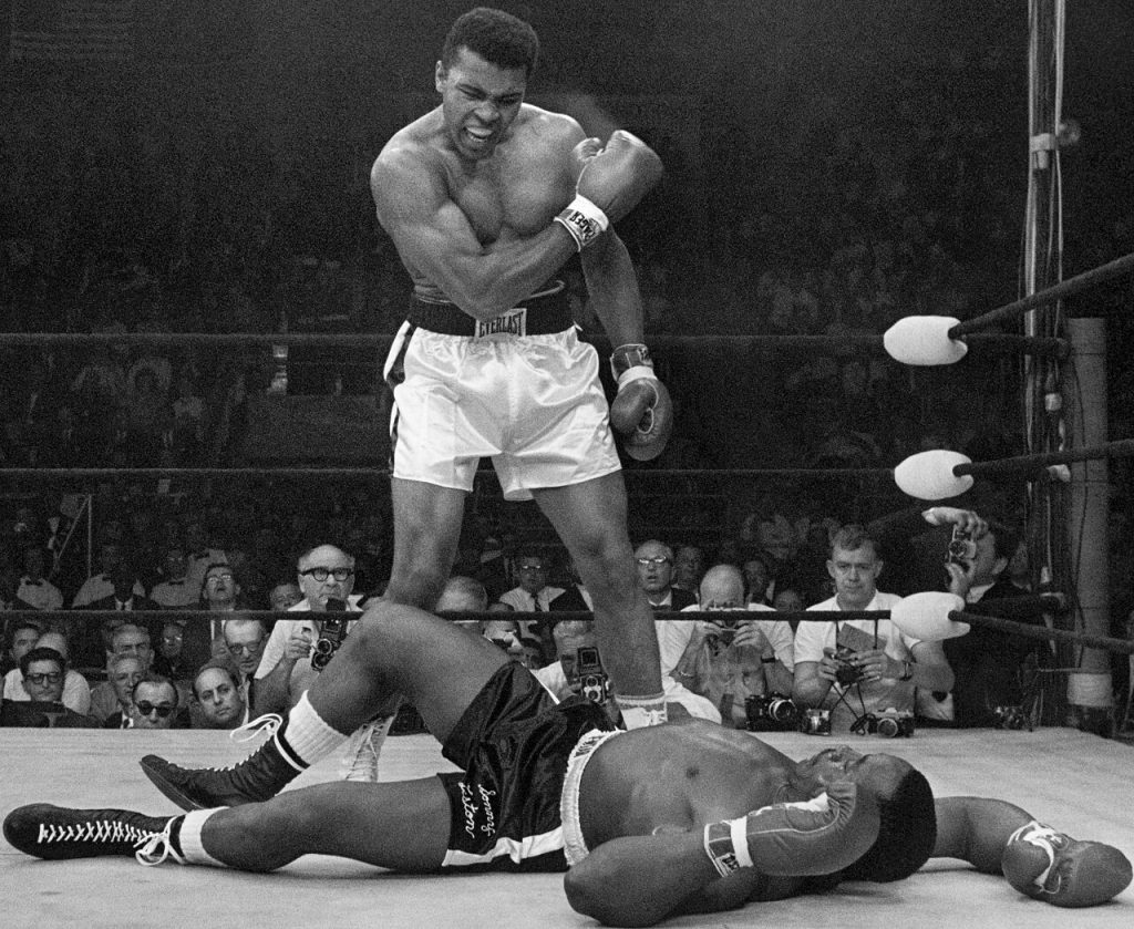 Black and white image of Mohammad Ali standing over Sonny Liston after a boxing match